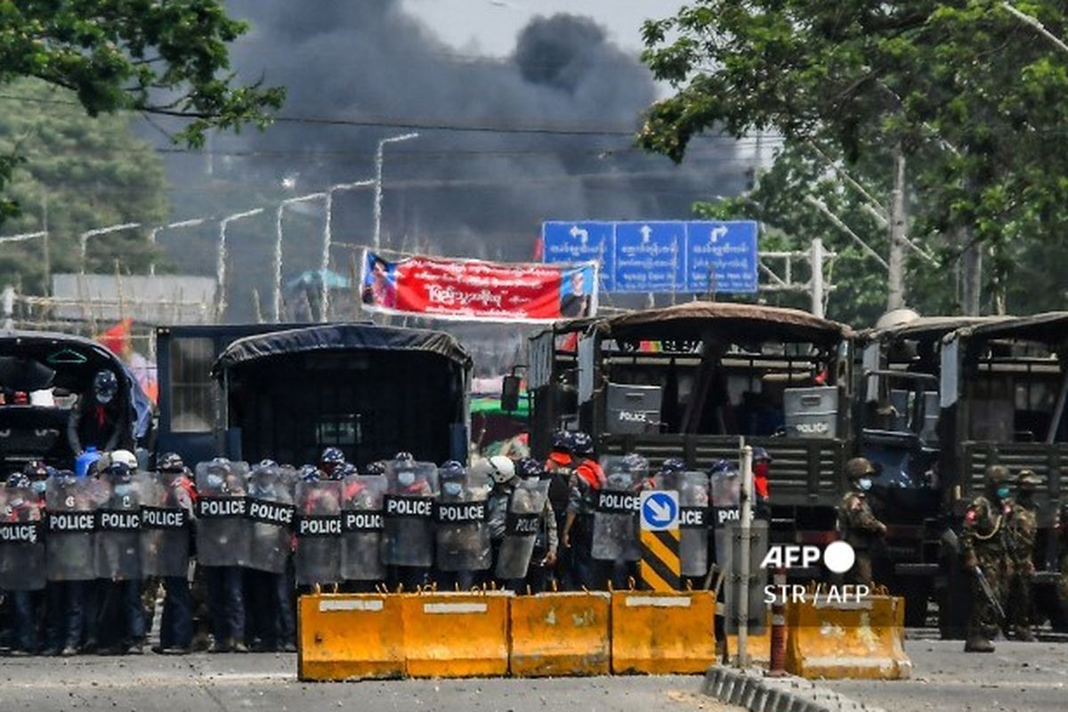 Security forces stand guard during a demonstration by protesters against the military coup in Yangon's Hlaing Tharyar township on March 14, 2021. (Photo by STR / AFP)