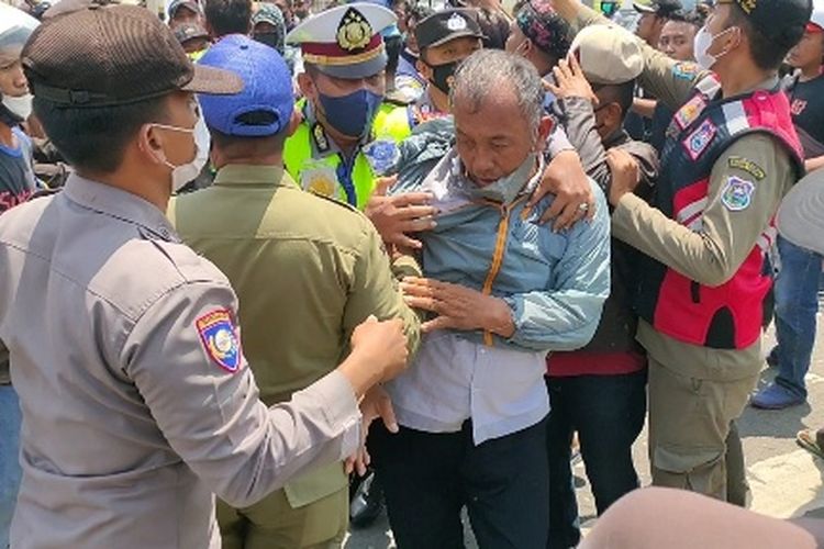 Polisi melerai sejumlah orang yang terlibat keributan dalam aksi damai turun ke jalan dalam rangka refleksi 3 tahun kepemimpinan Wali Kota Dedy Yon Supriyono di depan Gerbang Balai Kota Tegal, Rabu (23/3/2022). 