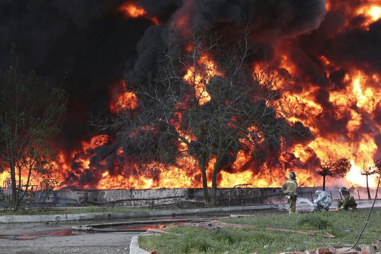 Situasi Darurat di Donetsk Petugas pemadam kebakaran Kementerian bekerja di lokasi kebakaran di depot minyak setelah rudal menghantam fasilitas di daerah yang dikendalikan oleh pasukan separatis yang didukung Rusia di Makiivka, 15 km (94 mil) timur Donetsk, Ukraina timur, Rabu, 4 Mei 2022. 