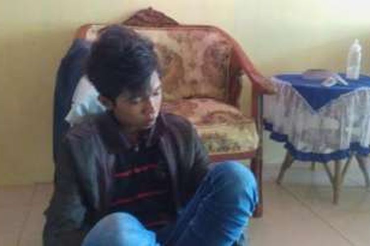 Ismed Banda (18), pemuda yang diduga berpose duduk di atas kepala patung pahlawan, saat diamankan Satuan Koramil Pardagangan, Minggu (8/5/2016).