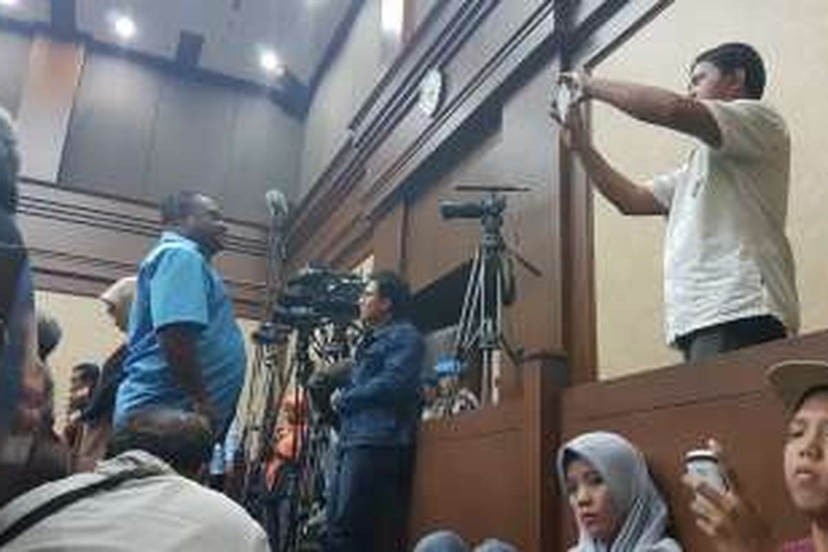 Warga yang menontong langsung sidang kasus kematian Wayan Mirna Salihin mengabadikan momen dengan berfoto di dalam ruang sidang Pengadilan Negeri Jakarta Pusat, Senin (19/9/2016) malam.