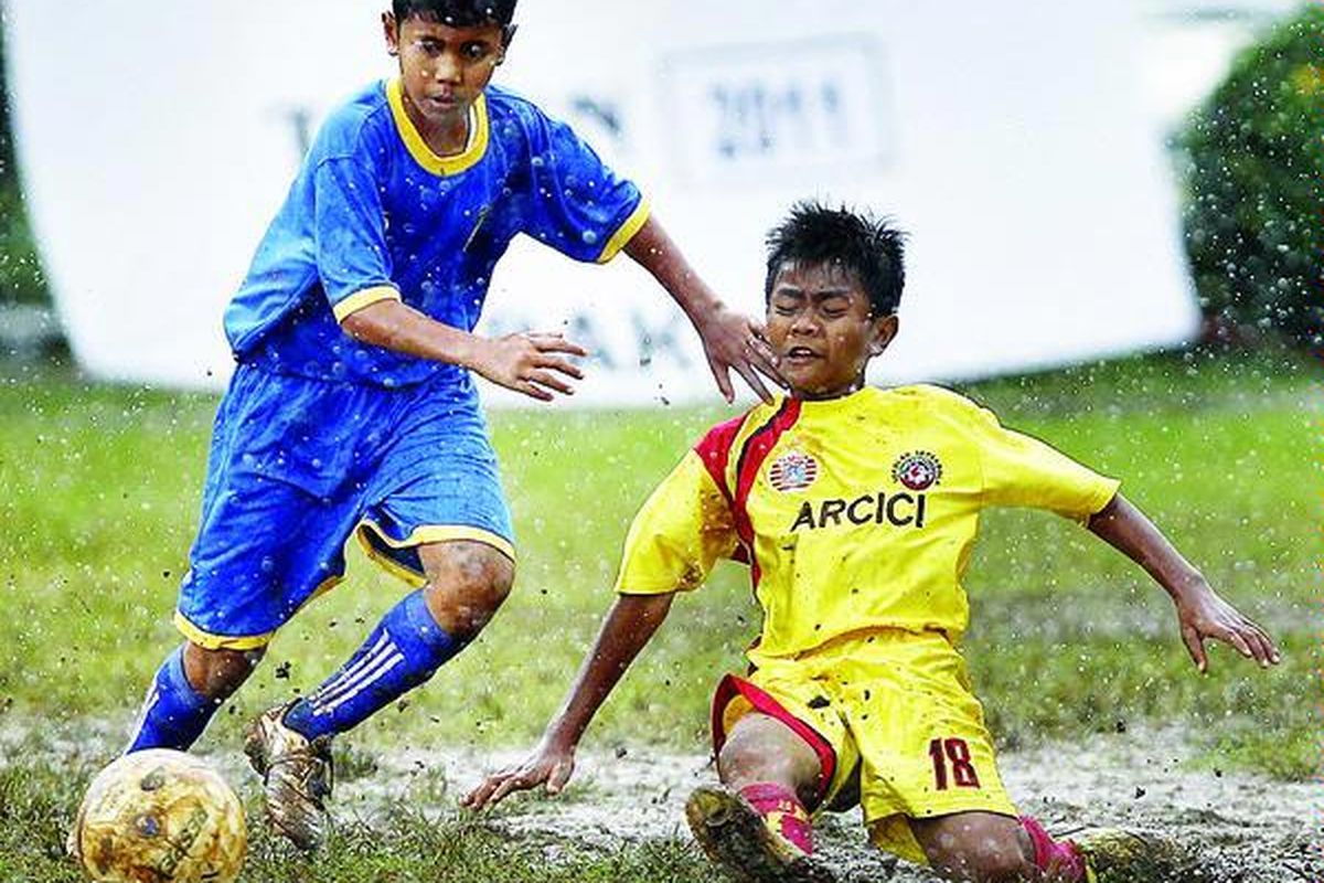 Pemain SSB Metro Depok, Hengky Saputra (kiri), berebut bola dengan pemain SSB Mutiara Cempaka, Adam Bima Saputra, dalam babak play off Liga Kompas Gramedia U-14 di Lapangan Pertamina, Simprug, Jakarta, Minggu (16/1).