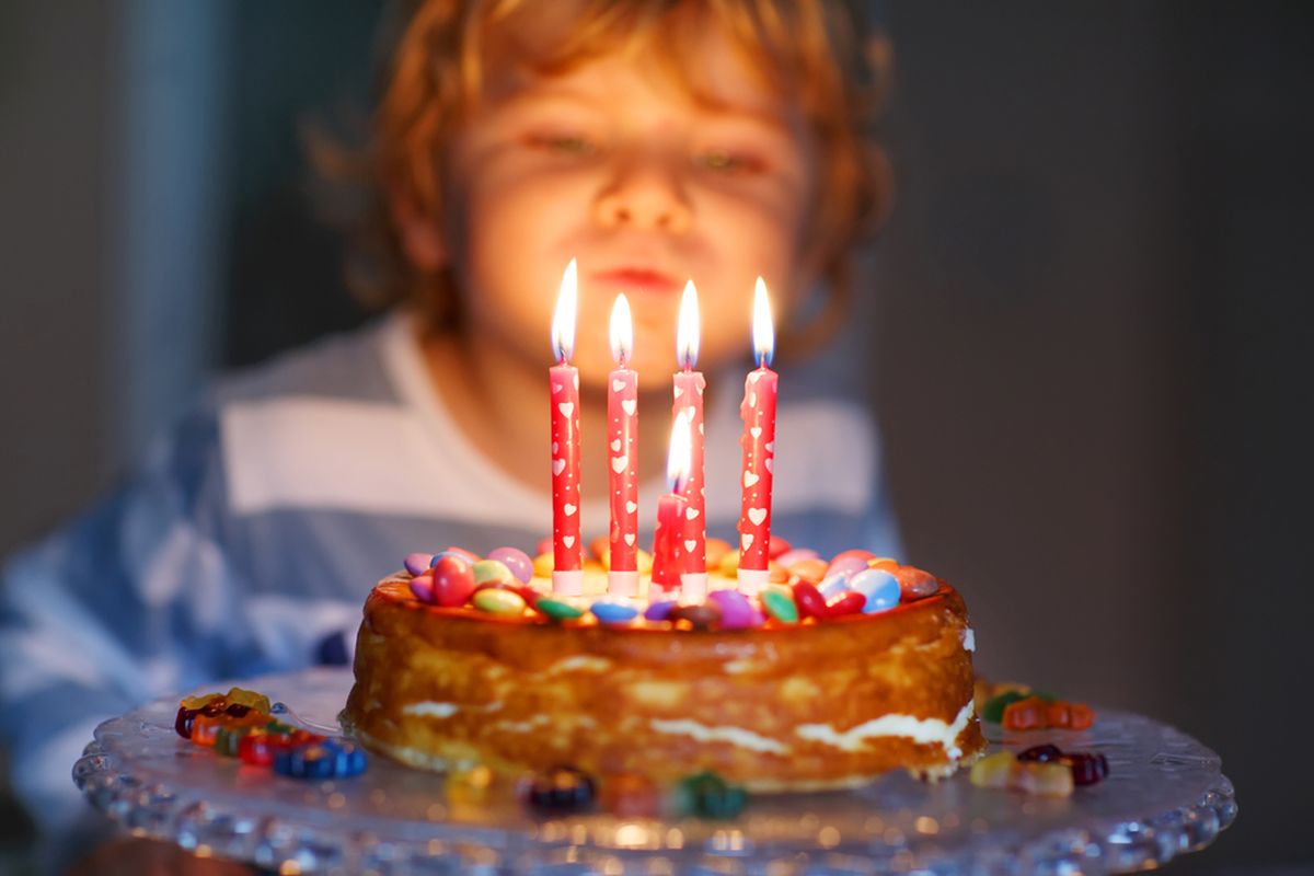 Ilustrasi meniup lilin kue ulang tahun. Sejarah makan kue ulang tahun dan meniup lilin.