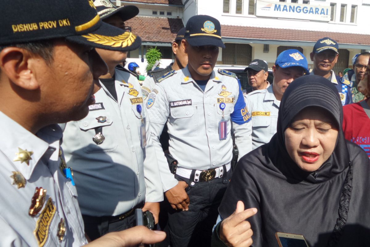 Seorang warga adu mulut dengan petugas dari Dinas Perhubungan DKI Jakarta saat razia bemo di kawasan Stasiun Manggarai, Jakarta Selatan. Perempuan tersebut tak terima petugas menertibkan bemo yang ada di kawasan itu. Ia menyebut belum da solusi yang ditawarkan oleh Pemprov DKI untuk menggantikan angkutan bemo dengan tarif murah, Jumat (16/6/2017)