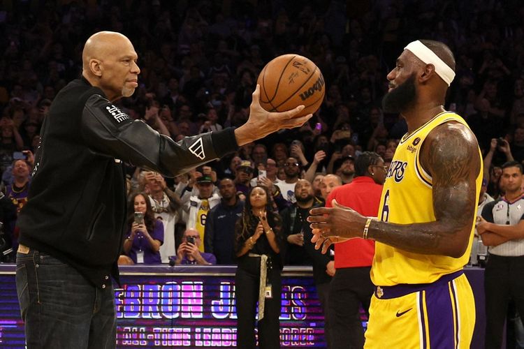 Megabintang Los Angeles Lakers, LeBron James menerima bola seremonial dari legenda basket AS, Kareem Abdul-Jabbar, setelah berhasil memecahkan rekornya sebagai pencetak poin terbanyak dalam sejarah NBA dengan 38.388 poin pada laga Los Angeles Lakers vs Oklahoma City Thunder, Rabu (8/2/2023) pagi WIB.