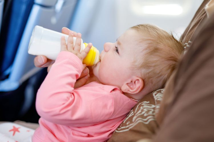 Bayi minum susu di pesawat
