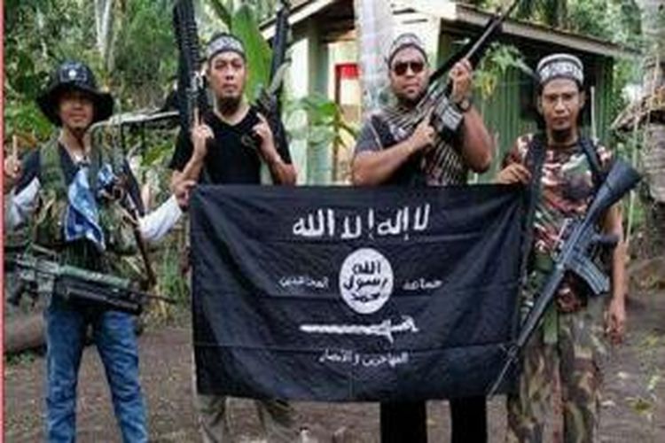 Dari kiri pejuang Abu Sayyaf, Mahmud Ahmad, Muhammad Joraimee Awang Raimee dan Muamar Gadafi, berfoto dengan bendera ISIS