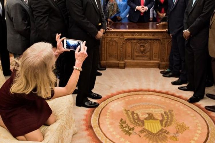 Penasihat senior Presiden Donald Trump, Kellyane Conway nangkring di atas sofa saat berusaha mengabadikan sang presiden bersama para tamunya pemimpin perguruan tinggi kulit hitam di AS.