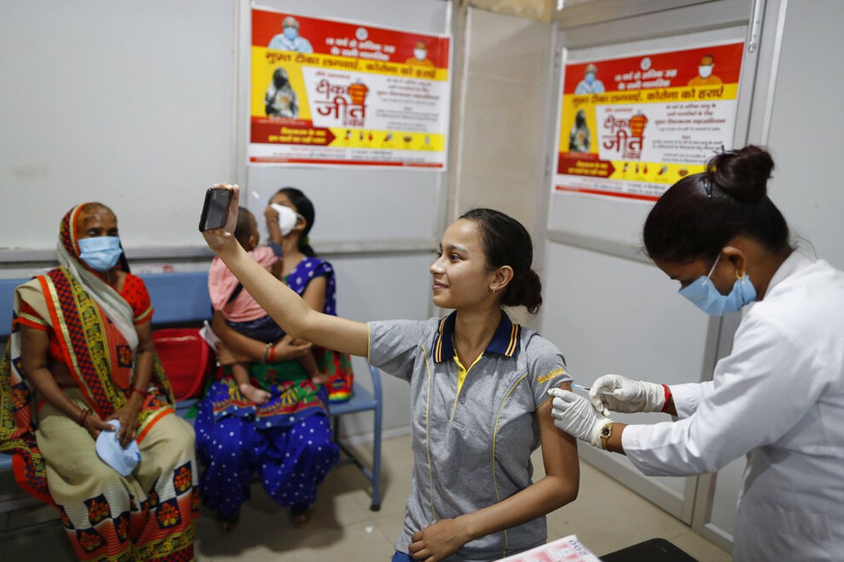 Seorang wanita India berswafoto saat petugas kesehatan memberikan vaksin Covid-19 di Rumah Sakit Wanita Pemerintah Distrik di Varanasi, India, Sabtu, 28 Agustus 2021. 