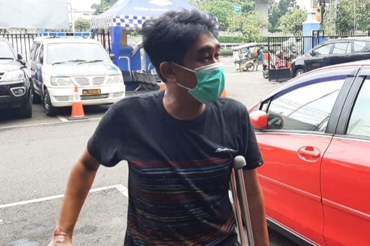 Seorang wartawan radio ternama, Eddy Suroso berjalan pincang dibantu tongkat di lengan kiri saat mendatangi kantor Subdit Gakkum di Pancoran, Jakarta Selatan, Kamis (26/5/2022) siang.