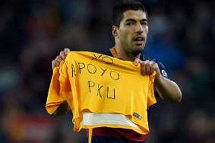 Luis Suarez menunjukkan kaus bertuliskan 