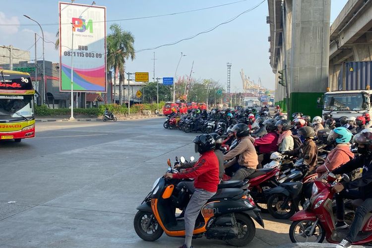 Pengendara sepeda motor dari arah Jalan Sulawesi menuju Jalan Enggano yang melamggar marka jalan pembatas garis putih di Persimpangan Mambo, Jakarta Utara, Senin (13/11/2023).