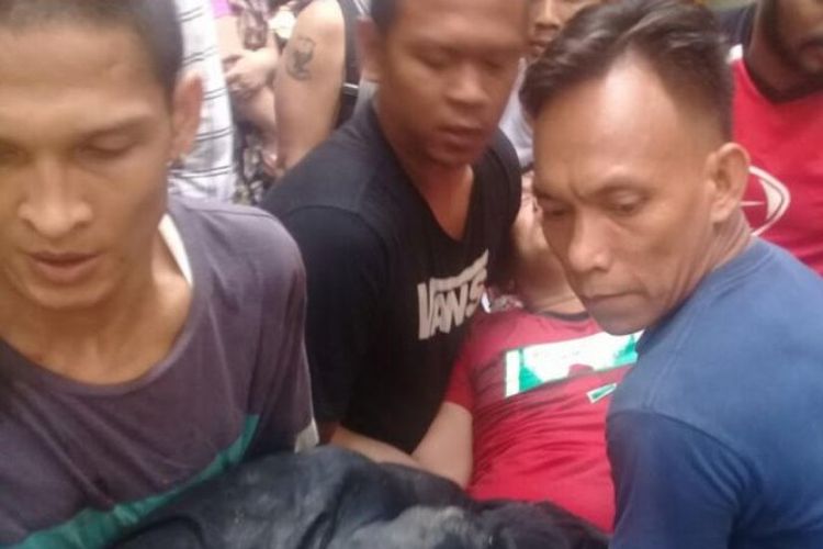 Bripka Eric Tambunan digotong warga setelah dikeroyok di Kampung Kubur, Medan, Sumatera Utara, Sabtu (14/4/2018).