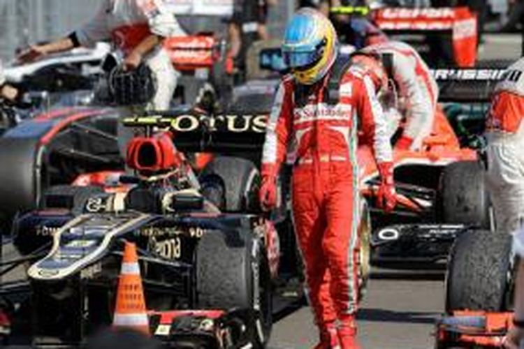 Pebalap Ferrari, Fernando Alonso, melihat mobil-mobil dari tim lain, usai balapan GP Hongaria di Sirkuit Hungaroring, Minggu (29/7/2013).