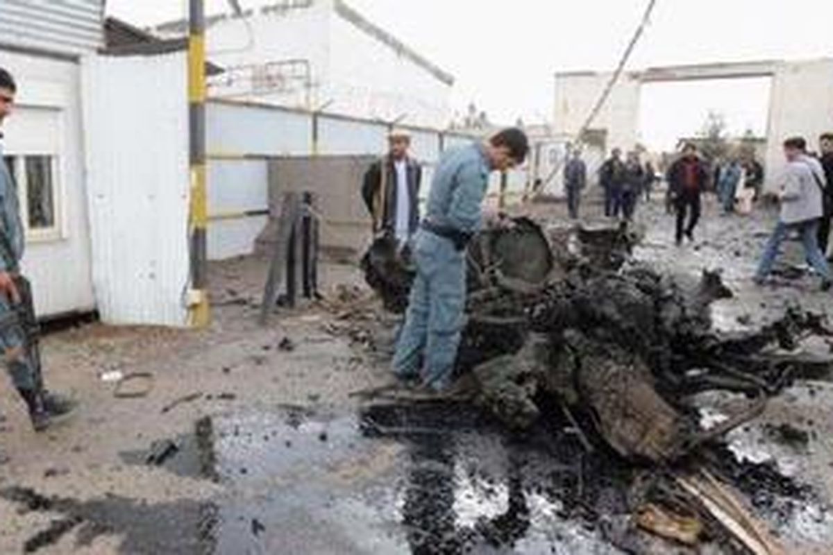 Polisi Afganistan memeriksa puing-puing sebuah mobil yang digunakan dalam serangan di luar tempat sebuah perusahaan logistik yang bekerja sama dengan pasukan pimpinan Amerika di pinggiran kota Herat, pada 3 November 2011.