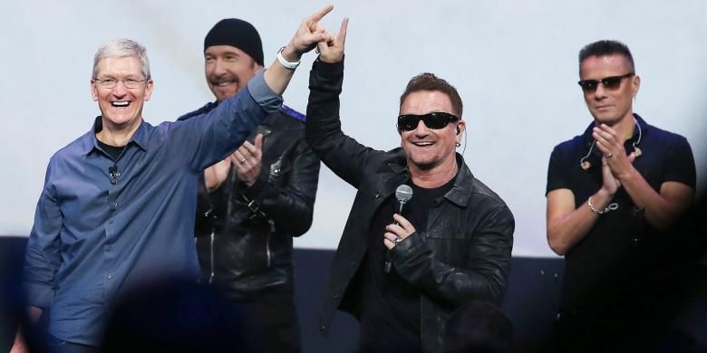 Para personel band rock Irlandia U2, yaitu Bono (kedua dari kanan), The Edge (kedua dari kiri), dan Larry Mullen Jr (paling kanan) berfoto bersama CEO Apple, Tim Cook (paling kiri), di Flint Center, Cupertino, California, AS, dalam acara peluncuran tiga produk terkini perusahaan tersebut, pada 9 September 2014 waktu setempat.