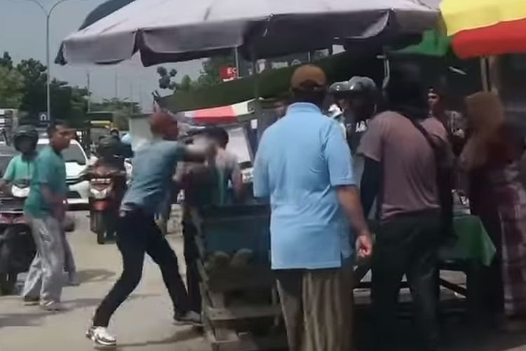 Sejumlah warga saat menghakimi seorang ODGJ yang menabrak mobil di Jalan HR Soebrantas, Kota Pekanbaru, Riau, Senin (1/7/2024).