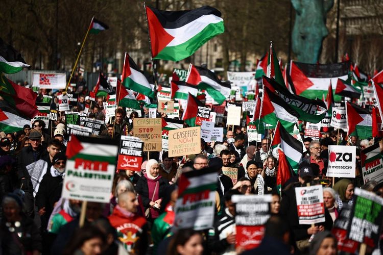 Aktivis dan pendukung pro-Palestina mengibarkan bendera dan membawa plakat dalam pawai melalui London, pada Hari Aksi Nasional untuk Palestina pada 9 Maret 2024.