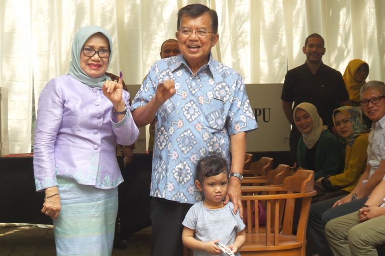 Wakil Presiden Jusuf Kalla dan Ibu Mufidah Kalla menunjukkan kelingking yang yang telah dicelupkan tinta usai mencoblos di TPS 03, Kelurahan Pulo, Kecamatan Kebayoran Baru, Jakarta Selatan, Rabu (19/4/2017).