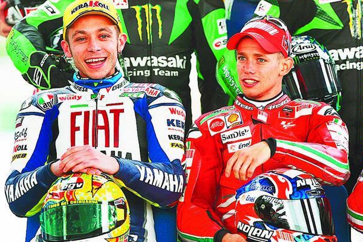 Pembalap Italia, Valentino Rossi (kiri), bercakap-cakap dengan pembalap Australia, Casey Stoner, pada acara sesi foto di Sirkuit Jerez, Februari lalu. Keduanya bersaing ketat dalam perebutan menuju tangga juara MotoGP tahun 2008.  