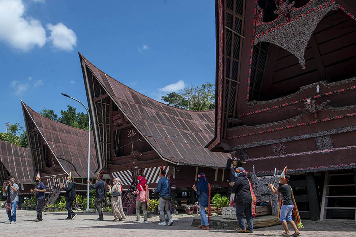 Foto dirilis Jumat (5/3/2021), memperlihatkan wisatawan menari Tor Tor di depan patung Sigale-gale di Desa Wisata Tomok, Simanindo, Samosir, Sumatera Utara. Pemerintah Indonesia saat ini tengah menyiapkan Danau Toba di Sumatera Utara sebagai lokasi Destinasi Pariwisata Super Prioritas (DPSP) untuk menggantikan Pulau Bali.