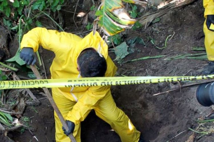 Foto ini dirilis pada 15 Januari 2018 oleh Jaksa Agung negara bagian Nayarit, Meksiko. Dalam foto tersebut nampak seorang pria menggali sebuah kuburan tersembunyi di Xalisco, negara bagian Nayarit, Meksiko. (Jaksa Agung Nayarit via AP)