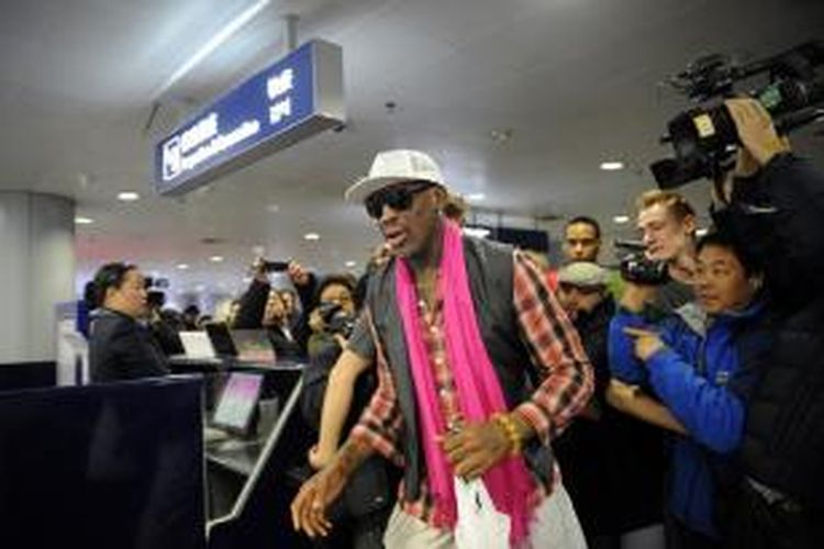 Mantan bintang NBA Dennis Rodman melewati kerumunan wartawan di Bandara Beijing, China. Rodman bersama sejumlah 