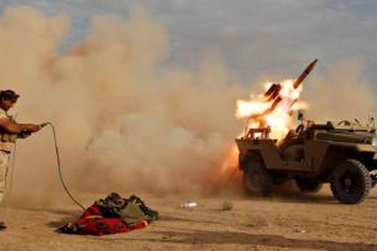 Seorang pejuang milisi Syiah meluncurkan roket dalam bagian kampanye militer untuk merebut kota Tikrit dari tangan ISIS.