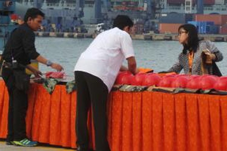 Petugas menyusun rompi dan helm di atas meja yang disiapkan di Dermaga 302, Pelabuhan Tanjung Priok, Jakarta Utara, Rabu (22/10/2014) petang. Di tempat ini, Presiden Joko Widodo akan menggelar acara khusus.