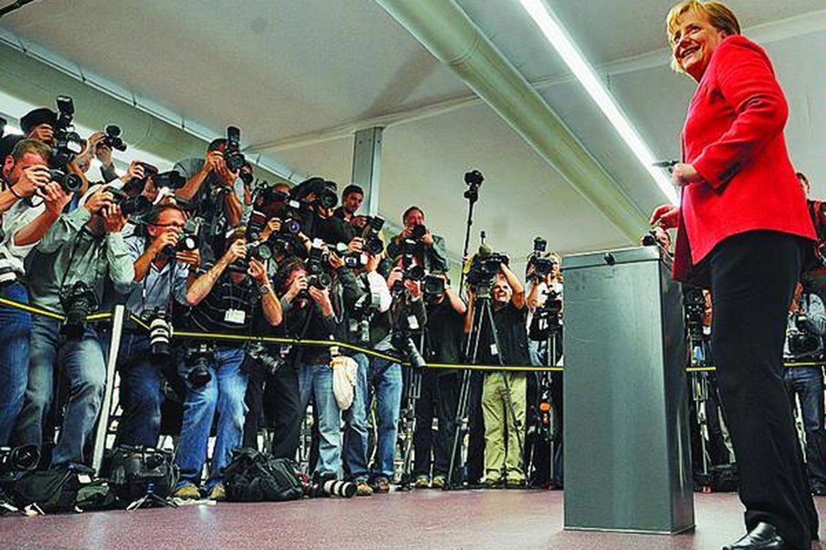 Kanselir Jerman Angela Merkel memasukkan kertas suara ke kotak di distrik Mitte, Berlin, Minggu (27/9). Pada hari yang sama, Jerman melakukan pemilu parlemen nasional.