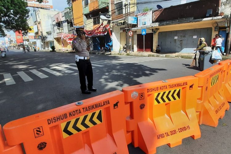 Perugas Kepolisian dan TNI menjaga penyekatan jalan di pusat Kota Tasikmalaya saat PPKM Darurat diperpanjang sampai tanggal 25 Juli 2021.