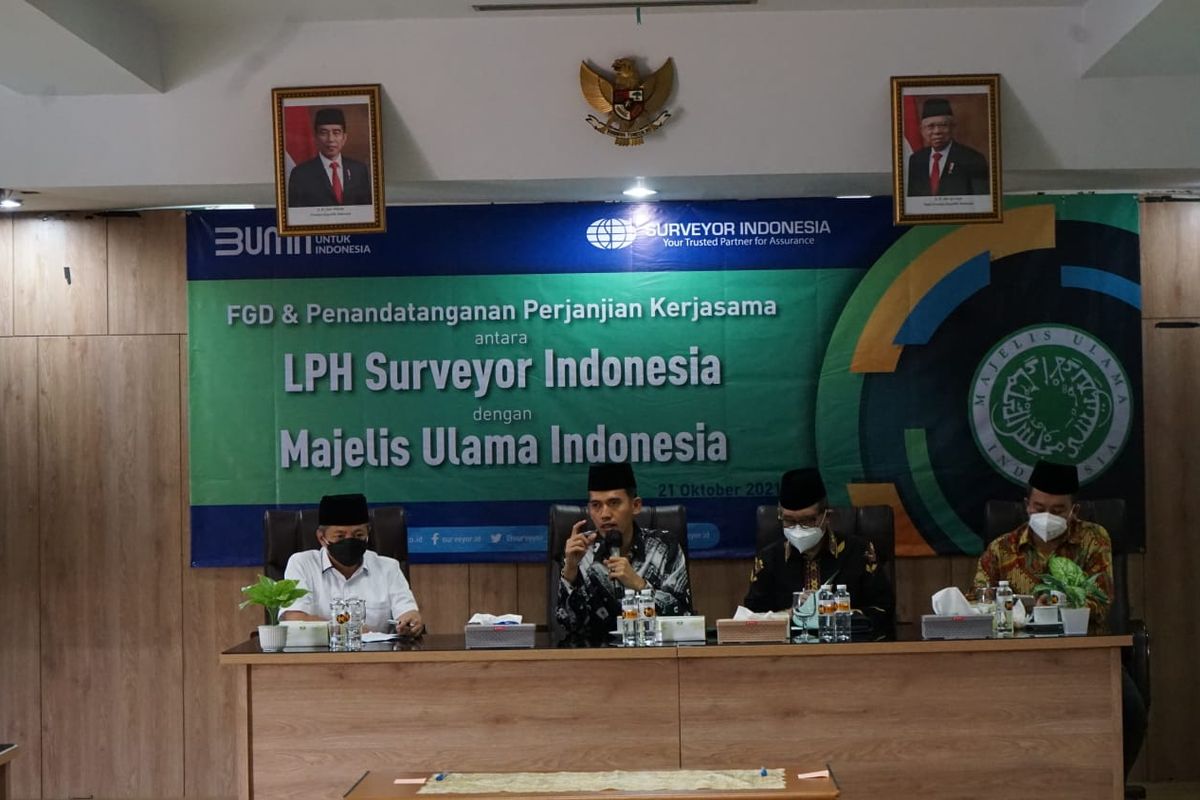 Direktur Utama PT Surveyor Indonesia M Haris Witjaksono (kiri) dan Ketua MUI Bidang Fatwa Asrorun Niam Sholeh (kedua dari kiri) dalam penandatanganan MoU tentang penetapan kehalalan produk oleh MUI dalam proses sertifikasi produk halal di Jakarta, Kamis (21/10/2021).