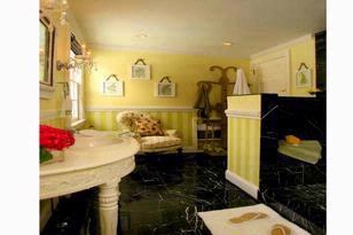 Nuansa kuning-kehijauan pada dinding dan tumbuhan rambat berwarna pink menyajikan kontras yang cantik dengan lantai marmer hitam dan warna kalem yang mendominasi keseluruhan ruangan.