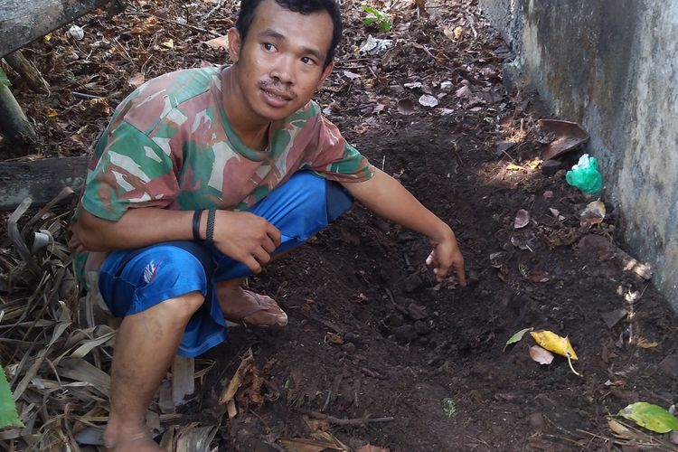 Warga menunjukkan lubang lokasi ditemukannya jasad FHA (18) di samping pekarangan rumahnya Desa Bajing, Kecamatan Kroya, Kabupaten Cilacap, Jawa Tengah, Senin (18/11/2019).