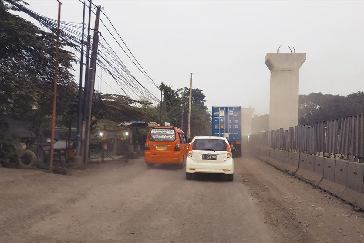 Debu beterbangan di Jalan Raya Bekasi, Jakarta Timur, yang sedang ada pengerjaan proyek Jalan Tol Pulogebang-Semanan.