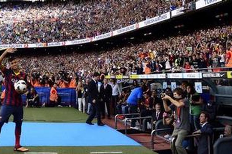 Pemain baru Bacelona, Neymar da Silva Santos Junior, melambaikan tangan saat perkenalan dirinya di Camp Nou, Senin (3/6/2013).