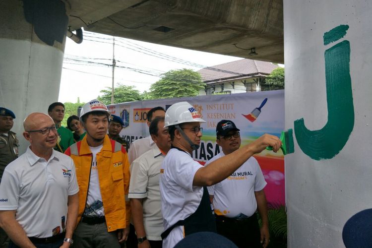 Gubernur DKI Jakarta Anies Baswedan melukis mural di tiang Jalan Layang Non-tol Antasari, Sabtu (10/3/2018). 