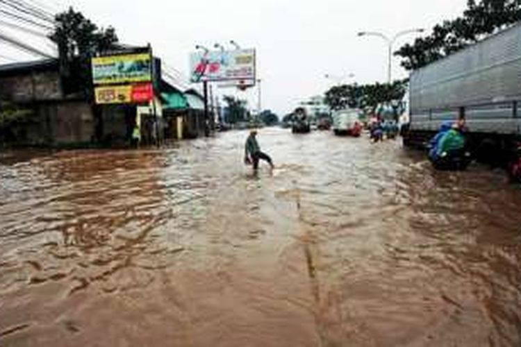 Warga melintasi banjir yang menggenang di Jalan Soekarno-Hatta, Gedebage, Kota Bandung, Jawa Barat, Senin (14/11). Meski sudah terpasang pipa sedot penerapan tol air sebagai proyek percontohan penanggulangan banjir, kawasan ini masih terendam cukup lama dan mengganggu lalu lintas. 