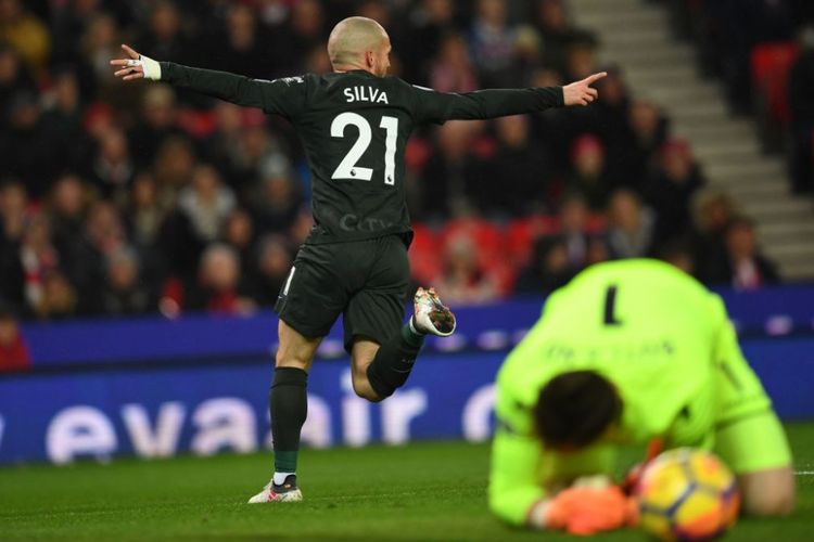 Gelandang Manchester City, David Silva, merayakan golnya ke gawang Stoke City yang dijaga Jack Butland pada pertandingan Premier League di Stadion Bet365, Senin (12/3/2018). 