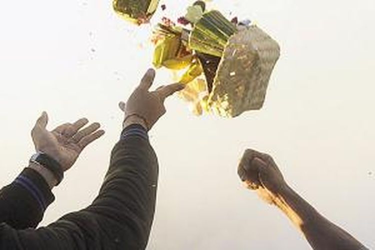 Sejumlah orang berebut menangkap sesaji yang dilemparkan oleh warga Tengger ke kawah Gunung Bromo di Kabupaten Probolinggo, Jawa Timur, pada puncak perayaan Yadnya Kasada, Selasa (12/8/2014). Yadnya Kasada merupakan ritual warga suku Tengger dengan melarung hasil bumi atau ternak ke kawah Bromo sebagai wujud syukur dan penghormatan kepada leluhur mereka.