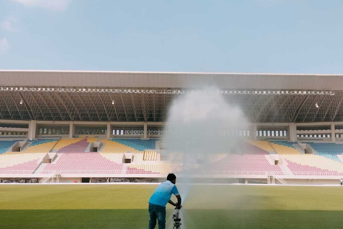 Petugas sedang melakukan perawatan dan menyiram rumput Lapangan Stadion Manahan Kota Solo, Jawa Tengah.