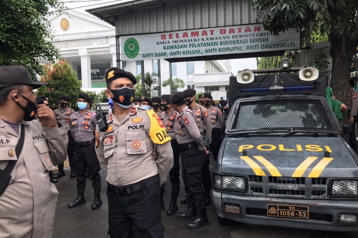 Polisi memblokade sebagian pintu masuk Pengadilan Negeri Jakarta Timur (PN Jaktim) dengan mobil pengeras suara pada Selasa (30/3/2021) pagi.