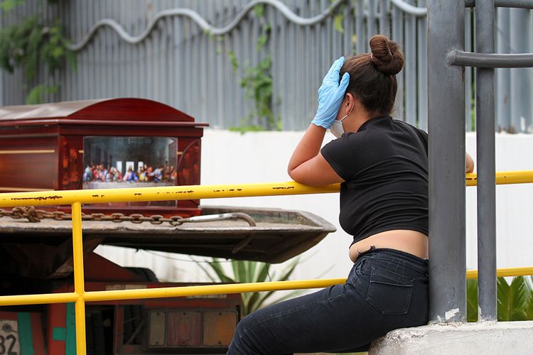 Seorang wanita dengan masker wajah dan sarung tangan menunggu jenazah kerabatnya di luar sebuah rumah sakit di Guayaquil, Ekuador, Rabu (1/4/2020). Otoritas Ekuador dalam beberapa hari terakhir telah mengumpulkan setidaknya 150 jenazah dari jalan-jalan dan rumah para warga di Kota Guayaquil, di tengah lonjakan kasus virus corona di wilayah tersebut.