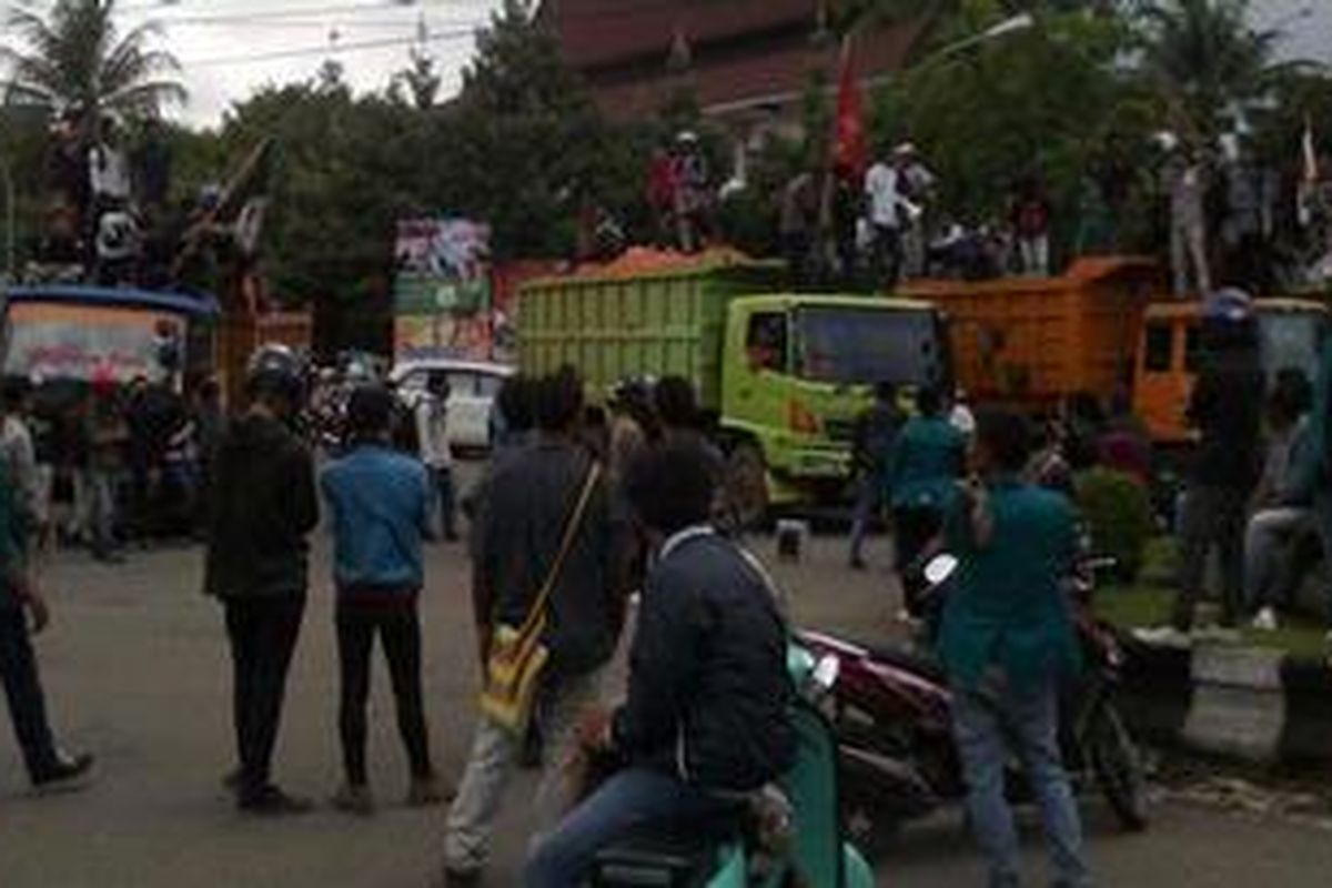 Ratusan mahasiswa Universitas Indonesia Timur (UIT) menyandera lima truk di pertigaan Jl AP Pettarani-Jl Hertasning, Makassar, Senin (10/12/2012).