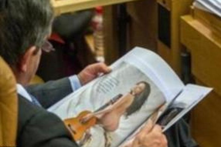 Politisi Spanyol Miguel Angel Revilla tertangkap kamera wartawan saat tengah membaca sebuah majalah dewasa di tengah-tengah sebuah sesi sidang parlemen.