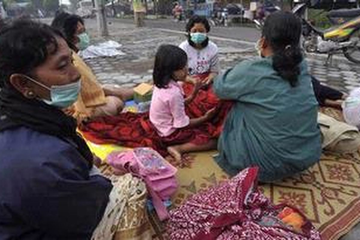 Sejumlah warga Manisrenggo mengungsi di tepi jalanan Desa Tlogo, Kecamatan Prambanan, Klaten, Jawa Tengah, Minggu (7/11) pagi, untuk menghindari dampak letusan Gunung Merapi. Warga terpaksa mengungsi dari rumah mereka yang berjarak sekitar 20 kilometer dari Merapi saat tiba-tiba terdengar suara gemuruh dan dentuman tak henti-henti menjelang Subuh. 