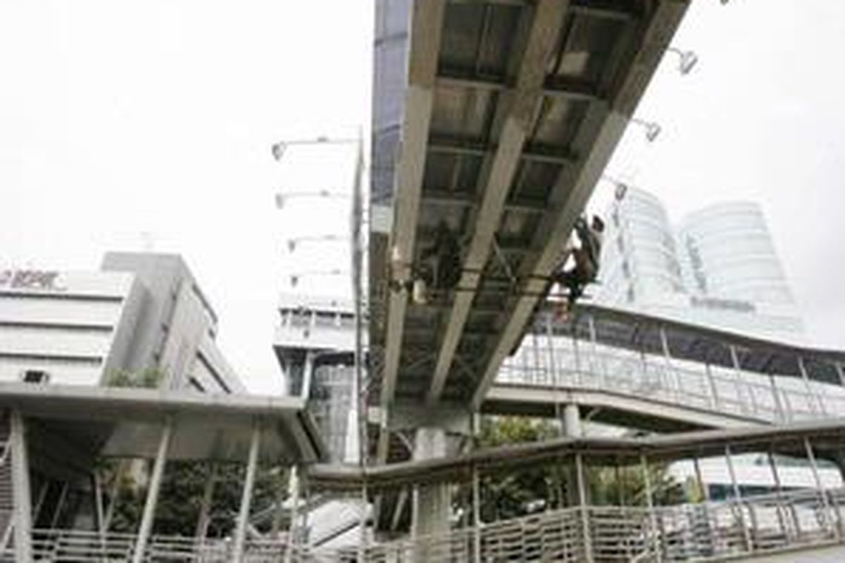 Dua orang pekerja mengecat jembatan penyeberangan orang (JPO) di Jalan HR. Rasuna Said, Jakarta Selatan, Selasa (6/10). Pengecatan tersebut merupakan upaya menjaga kebersihan dan keindahan JPO yang berada di kawasan perkantoran. 