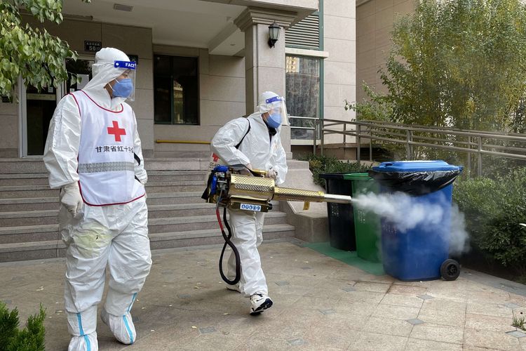 Pekerja melakukan penyemprotan disinfektan di sebuah kompleks perumahan di Lanzhou, Provinsi Gansu, China, Selasa (26/10/2021). Penyebaran Covid-19 di China kembali menjadi peringatan setelah klaster baru terkait sekelompok wisatawan ditemukan 17 Oktober lalu.