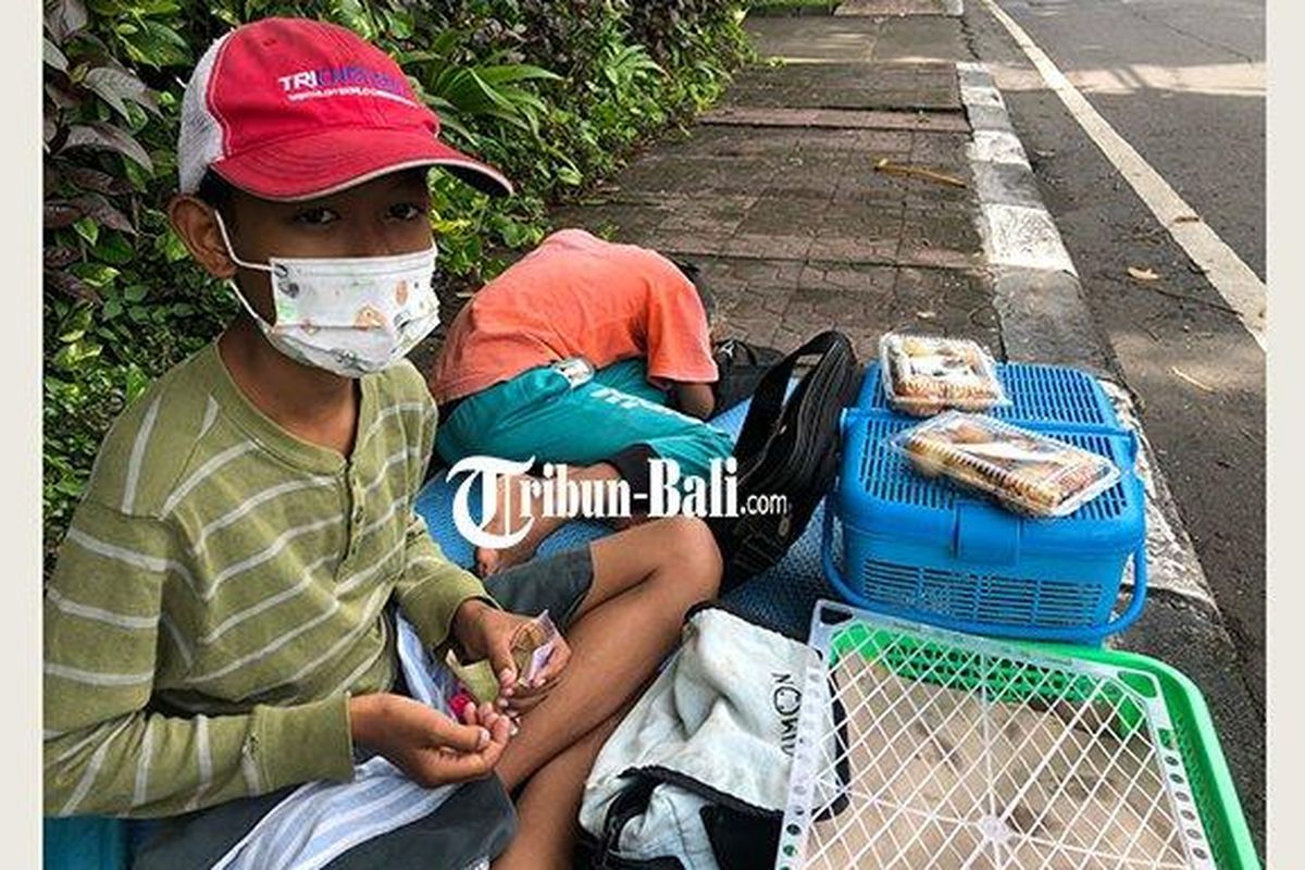 Firman bocah kelas 4 SD yang menjual jajanan di pinggir Jalan Hayam Wuruk Denpasar untuk membeli HP, Kamis 10 Februari 2022. 