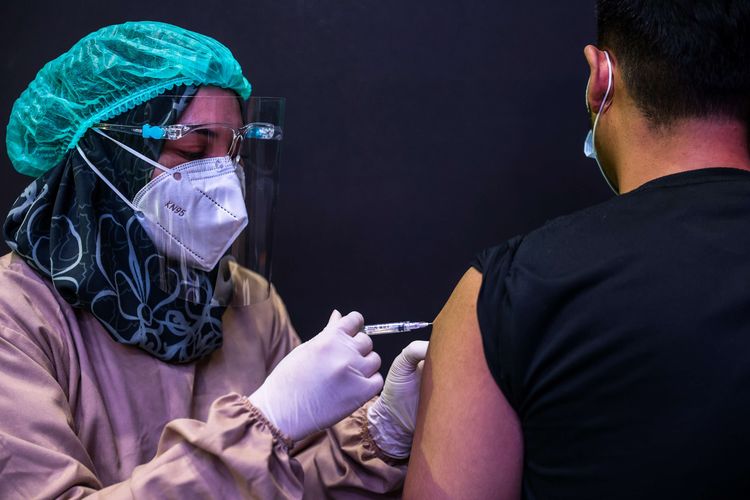 Vaksinator menyuntikkan vaksin Covid-19 Sinovac di Holywings Gatot Subroto, Jakarta, Senin (2/8/2021). Akselerasi vaksinasi Covid-19 ini diharapkan dapat menekan laju penyebaran Covid-19. Sebelumnya, Jokowi menargetkan vaksinasi 1 juta per hari pada Juli dan 2 juta per hari pada Agustus.